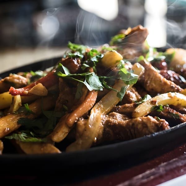 Steaming hot fajitas with meat, peppers, and onions, garnished with fresh cilantro.